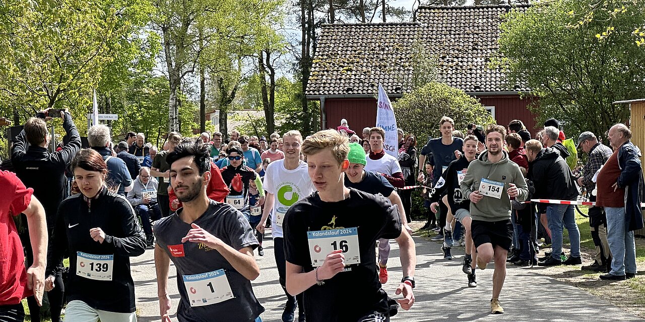 Junge Sportlerinnen und Sportler laufen im Freien im die Wette