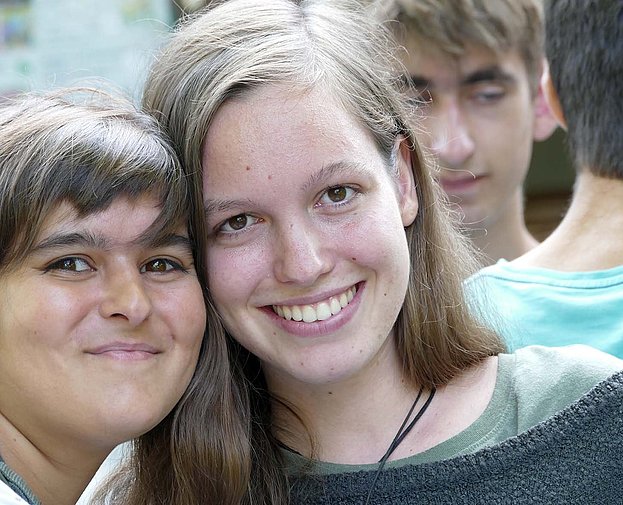 Zwei junge Frauen lächeln gemeinsam in die Kamera